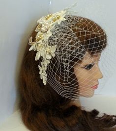 a woman wearing a birdcage veil with flowers on it's head and hair