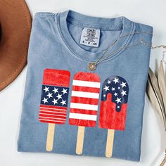 Popsicle Shirt, 4th Of July Shirt, Family Matching Shirt, Patriotic Popsicle Tee, Red Blue White Popsicle, Comfort Colors HOW TO ORDER 1. Check our photos for color and sizing options.  2. Choose your quantity. 3. Select your size and color from the drop-down menus. 4. Click "ADD TO CART" to add the shirt to your virtual cart.  5. Click "PROCEED TO CHECKOUT" to purchase your shirt.  6. Your shirt is now off to production! We will process your order and your shirt will be ready to ship in 1-3 day Blue Americana Flag Print Top, Blue American Flag Top For 4th Of July, Blue American Flag Tops, Americana Blue Top With Flag Print, American Style Blue T-shirt For 4th Of July, American Style Blue Tops For Independence Day, Blue Americana Tops With American Flag, Blue Americana Top With American Flag, American Flag Print Blue Tops