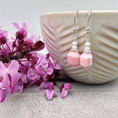 Pretty pink conch shell earrings. Made up of a larger faceted pink bead with a stack of 2 pale pink beads on top. The larger bead is darker in color and some show the striped lines of the many layers of the shell. Paired with shiny 925 sterling silver and French ear wires. All metal is solid 925 sterling silver.  Total Length of Earrings: just under 1-1/4 inches (28mm) The earrings are ready for shipping and will be shipped within 24-72 hours from purchase. They will arrive in a gift box with a Pink Faceted Earrings For Gift, Pink Faceted Earrings For Jewelry Making, Pink Faceted Drop Earrings, Elegant Pink Beaded Earrings With Faceted Beads, Elegant Pink Earrings With Faceted Beads, Pink Hypoallergenic Beaded Earrings With Round Beads, Pink Hypoallergenic Beaded Earrings For Gift, Hypoallergenic Pink Beaded Earrings For Gift, Pink Dangle Earrings With Faceted Beads