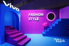 a purple and blue fashion show room with stairs