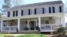 a white house with black shutters on the front porch