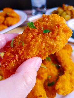 a person is holding up some fried food