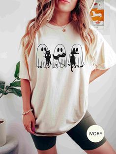 This adorable tee is perfect for any cat-loving horror fan. Great for Halloween, the simple graphic design makes it easy to layer with other tees and jackets. This shirt would also make a great gift for anyone who loves cats, cute ghost outfits and hauntingly cute pet designs. ✨ You get: - Extra coziness - A relaxed fit - Eye-catching designs ✨ Details: Comfort Colors Brand Shirt. Unisex Adult Sizing. 100% ring-spun cotton Soft-washed, Garment-dyed fabric Screen-printed directly onto the garment, no vinyl or heat transfer. ✨ Size: Our shirts are unisex sizing. Please see images for measurements and recommendations for oversized looks. ✨ Care Instructions: Machine wash: cold (30C or 90F), inside-out, gentle cycle with mild detergent and similar colors.  Do not bleach. Tumble dry: low heat. White Cat Print T-shirt For Halloween, Spooky Cat Print Crew Neck T-shirt, White T-shirt With Cat Print For Fall, Halloween White T-shirt With Cat Print, Halloween Cat Print Graphic Tee, White Cat Print T-shirt For Fall, Halloween Cat Print Crew Neck T-shirt, Halloween Party Family, Fabric Screen