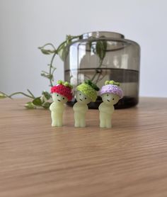 three small figurines sitting on top of a wooden table