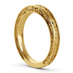 an intricately engraved wedding band in yellow gold