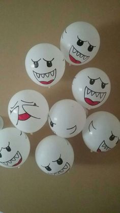 white balloons with faces painted on them