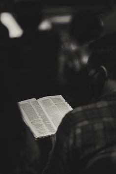 an open book sitting on top of a table next to a person wearing headphones