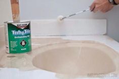 a person using a brush to paint a bathroom sink with the help of an adhesiver