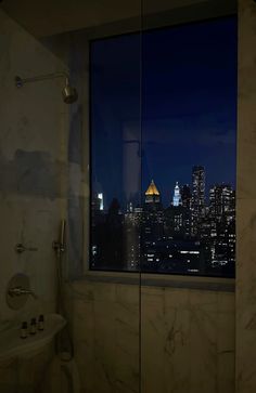 a bathroom with a view of the city at night