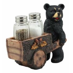 a bear figurine sitting on top of a wooden wagon filled with nuts and spices