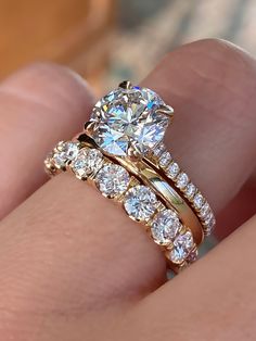 a close up of a person's hand with a diamond ring on their finger