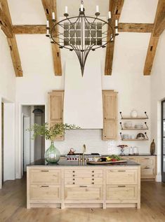 a large kitchen with wooden cabinets and an island in the middle, surrounded by wood beams