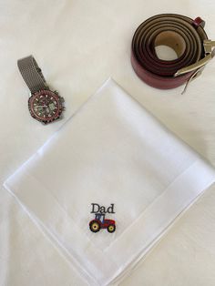 "Embroidered handkerchief with a \"tractor\" Fathers day motif The word \"DAD\" may be changed to a name if you wish to personalise the handkerchief.  These quality handkerchiefs are made from the softest cotton.  Size: 40x40cm (e)  Excellently crafted from 100% premium COTTON.  This comes in a beautiful gift envelope closed with a satin ribbon. The hankies are made to order. Lovely to have. stylish enough for daily use or as a special Fathers Day gift" Personalized Cotton Handkerchiefs, Classic Cotton Handkerchiefs As Gift, Embroidered Cotton Handkerchiefs As Gifts, Cotton Handkerchief With Machine Embroidery For Gift, White Cotton Handkerchiefs For Gifts, White Cotton Handkerchiefs Gift Set, Classic Handkerchiefs For Father's Day Gift, Embroidered Handkerchief, Gift Envelope