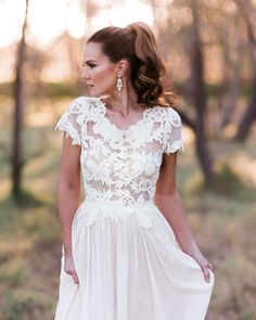 a woman wearing a white dress in the woods