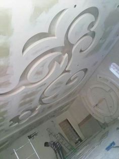 the ceiling is being painted white and has decorative designs on it, as well as other decorations