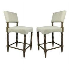 a pair of stools with white upholstered backrests and wooden legs