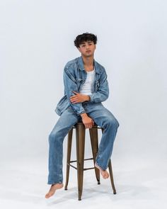 a man sitting on top of a metal stool