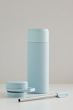 thermos are sitting on the table next to each other and one has a straw in it