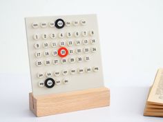 a calculator sitting on top of a wooden block next to an open book