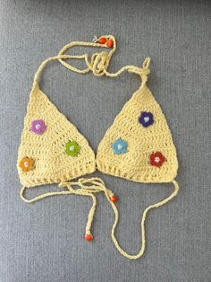 Handmade one of a kind crochet swim suit  top. The perfect yellow colored yarn detailed with bright flowered embellished with pearls is perfect for summer! Wear as a swimsuit or to a festival for a fun and unique look!                   Fits XS/S Fun Fitted Beach Top, Bohemian Beaded Swimwear For Beach, Bohemian Beaded Swimwear For Vacation, Spring Poolside Crochet Top, Beaded Triangle Top Swimwear For Summer, Beaded Swimwear For Beach Season Festivals, Beaded Swimwear For Beach Festival, Summer Festival Beaded Swimwear, Fitted Yellow Crochet Top For Summer