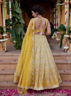 Elevate your style with a silver geometric mirror and leather appliqué embroidered skirt on vibrant yellow dupion silk fabric. Paired seamlessly with a heavily embroidered blouse and a tulle dupatta featuring a scallop border, adorned with pearls and sequence detailing, this ensemble is a celebration of craftsmanship and contemporary charm. Embellished Tissue Silk Lehenga For Festivals, Elegant Yellow Chanderi Choli, Festive Embellished Tissue Silk Lehenga, Festival Embellished Chanderi Choli, Gold Embellished Chanderi Lehenga, Designer Tissue Silk Lehenga With Mirror Work, Yellow Raw Silk Choli With Dupatta, Reception Chanderi Lehenga Embellished, Embellished Chanderi Lehenga For Festivals