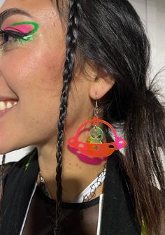 Take off on an intergalactic adventure with the Space Ranger Earrings! The ultimate accessory for those who have a passion for all things extraterrestrial. Carefully handmade with high-quality materials, these earrings are sure to last through every dance and festival adventure. - Made with lightweight acrylic for comfortable wear- Alien is UV-reactive green you can get the UFO ship either black glitter or uv reactive pink- Earring hooks are stainless steel, nickel-free, and hypoallergenic- Rubber backing included to keep things secure while you dance the night away! Funky Adjustable Dangle Earrings, Fun Dangle Earrings For Festival, Fun Dangle Earrings For Festivals, Adjustable Funky Earrings For Festivals, Rave Jewelry For Music Festival With Adjustable Fit, Trendy Single Earring For Festivals, Handmade Rave Jewelry For Party, Trendy Pierced Jewelry For Festival, Trendy Festival Drop Earrings