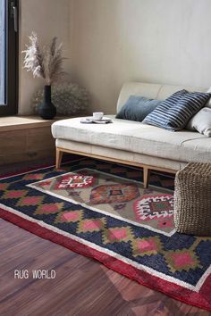 a living room with a couch, rug and window sill in front of it