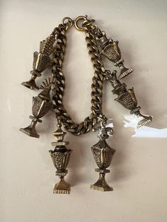 "Here is a unique vintage charm bracelet dating back to the late 50s/early 60s. There are 6 rather unique charms dangling from this gold plated curb link chain. The charms remind me of very fancy vases or possibly chess pieces. Each one is different. They all measure approximately 1 1/2\". There are no marking on the spring ring clasp. The clasp is brighter than the rest of the bracelet but I still think it is original. Fun bracelet to wear or collect." Early 60s, Fun Bracelet, Vintage Charm Bracelet, Charm Chain, 60s Vintage, Chess Pieces, 50s Fashion, Unique Charms, Charm Bracelets