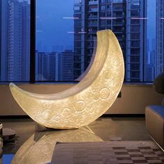 a large white moon sculpture sitting on top of a table in front of a window