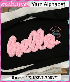 a black bag with pink crocheted letters on it