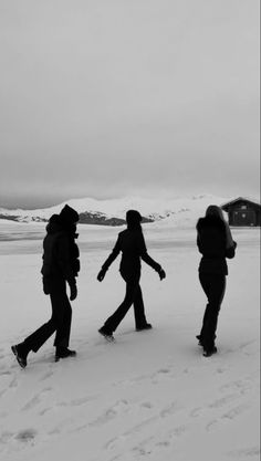 three people walking across snow covered ground