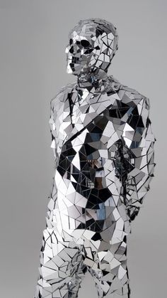 a sculpture made out of mirrors with a man in the middle and one arm up