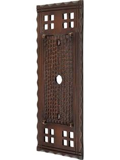 a decorative wall hanging with holes in the center and an intricately carved design on it