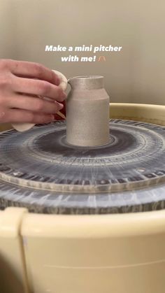 a person is making a vase out of clay