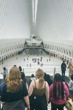 several people are standing in front of an escalator