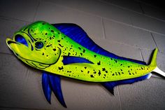 a yellow and blue fish is hanging on the wall