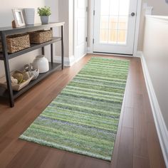 a green rug is on the floor in front of a white door and black shelf