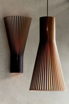 two wooden lamps hanging from the side of a wall