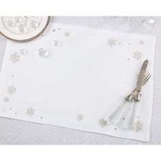 a white place mat with silverware and snowflakes