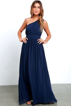 a woman in a blue dress posing for the camera with her hands on her hips