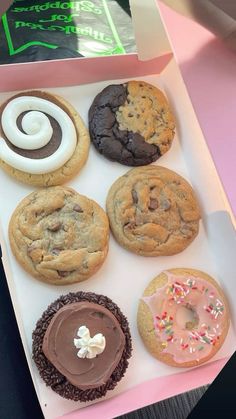 a box filled with lots of different types of cookies and doughnuts on top of a table