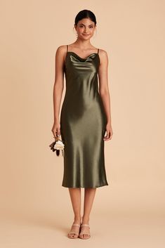 a woman wearing a green satin slip dress