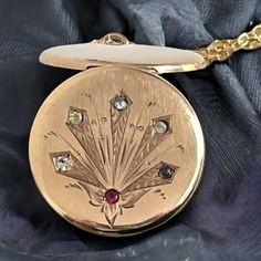 "Description: A patented design on an antique round gold filled locket necklace with an etched design and six \"paste\" stones on a new 14K gold filled chain. The front of this round antique hallmarked gold filled locket has a unique design with some etched leafy and geometric shapes accented with paste gems.  NOTE: What are paste stones? \"Paste\" stones are a type of cut glass that was produced to imitate the look of expensive gems. The most commonly used material for paste was lead glass. The Antique Medallion Locket Necklace Stamped 14k, Victorian Round Locket Necklace Stamped 14k, Collectible Yellow Gold Necklace With Antique Finish, Antique Engraved Rose Gold Necklace, Vintage Hallmarked Rose Gold Jewelry, Victorian Engraved Rose Gold Locket Necklace, Heirloom Oval Jewelry With Screw Back, Vintage Rose Gold Hallmarked Jewelry, Victorian Rose Gold Locket Jewelry