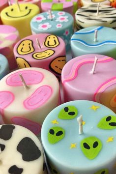 many different colored candles with faces on them