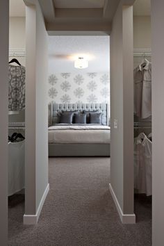 an open door leading to a bedroom with a bed in the corner and closets