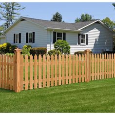 a wooden fence in front of a white house