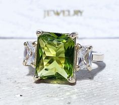 Don't miss this opportunity to own this beautiful gemstone ring crafted in 14k gold filled => Gemstone Type - Peridot, Clear Quartz => Gemstone Cut - Faceted => Gemstone Size - 8*10 mm, 3*5 mm => Total Number of Gemstones - 3 => Metal Type - 14k Gold Filled (Tarnish Resistant And Nickel Free) - also available in 925 sterling silver * Please contact me for pricing on a sizes larger than 11 * ~ Feel free to ask me about custom made designs. ❏ Replacements and custom orders : ✪ 925 sterling silver Rectangular 14k Gold Jewelry With Accent Stones, Fine Jewelry With Three Stone Rectangular Design, Gold Jewelry With Square Cut Accent Stones, Gold Rectangular Rings With Accent Stones, Rectangular Gold Rings With Accent Stones, Peridot Three Stone Jewelry As Gift, Rectangular Gold Jewelry With Accent Stones, Fine Jewelry Rectangular Three-stone, Square Cut Gold Jewelry With Accent Stones