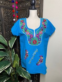 "Precious Embroidered Blouse made in Puebla, Mexico by our Mexican partners. Super light weight and fresh looking. The embroidered design is beautiful and delicate. All the work is clean, and with a professional finish and hand embroidered. You will look gorgeous for a friends night out or a summer cookout day, your call. You will Love it either way.... :) Blouse STYLE DETAIL Overview * soft cotton fabric * round-neck * hand embroidered design * short sleeves * 22\" UNDERARM TO UNDERARM, 28\" SH Traditional Short Sleeve Blouse With Tonal Embroidery, Traditional Cotton Blouse With Tonal Embroidery, Traditional Short Sleeve Embroidered Top With Tonal Embroidery, Traditional Short Sleeve Tops With Tonal Embroidery, Blue Top With Intricate Embroidery For Festivals, Blue Short Sleeve Folk Blouse, Blue Folk Style Short Sleeve Blouse, Traditional Blue Tops With Floral Embroidery, Traditional Blue Blouse With Geometric Embroidery