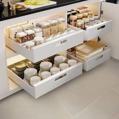 an open drawer in the middle of a kitchen with dishes and containers on it's sides