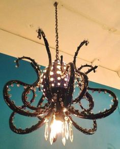 an octopus chandelier hanging from the ceiling in a room with blue walls and white trim